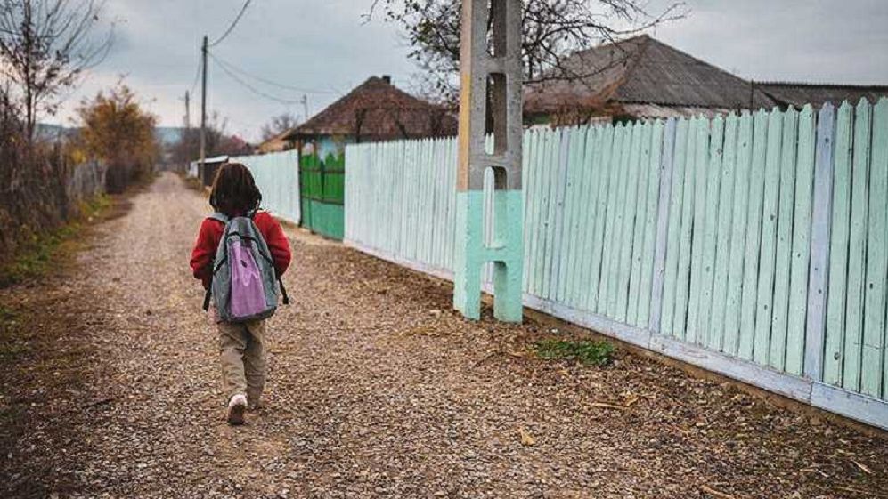 Copil din sat românesc mergând la școală, simbol al programelor UE pentru incluziune socială