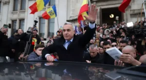 Călin Georgescu salută susținătorii înconjurați de steaguri ale României